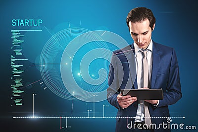 Attractive young european businessman using tablet with futuristic blue HUD interface and glowing programming code on blurry blue Stock Photo