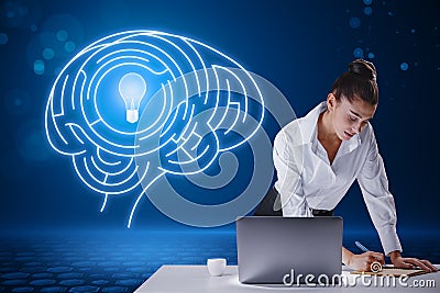 Attractive young european businesswoman leaning on desktop with laptop and writing abstract digital light bulb with human brain Stock Photo