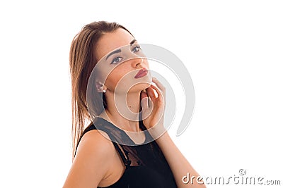 Attractive young girl in black clothes is worth turning sideways and keeps a hand near the face Stock Photo