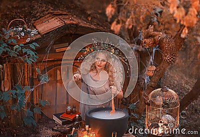 Attractive young girl with blond hair with an amazing lush wreath on her head in the forest is preparing a large Stock Photo