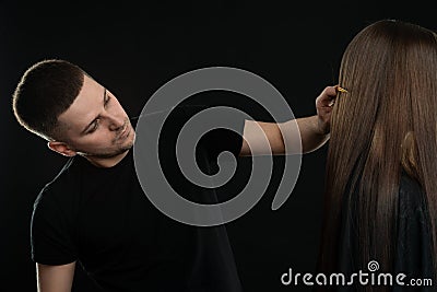 Attractive young Hair Dresser Combing Clients Hair In Salon Stock Photo