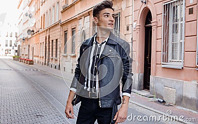 Attractive young hipster man in black jacket. fashionable walks in the city. Urban fresh portrait confident young man Stock Photo