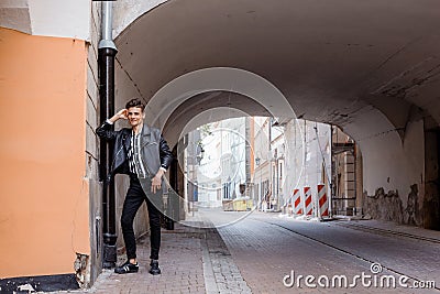 Attractive young hipster man in black jacket. fashionable walks in the city. Urban fresh portrait confident young man Stock Photo
