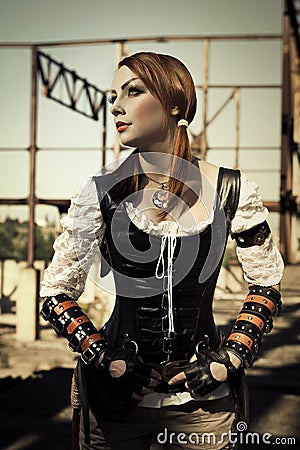 Attractive young l woman in leather corset posing outdoors. Stock Photo