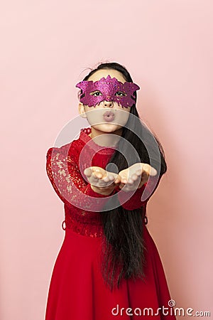 Attractive young lady sending blowing air kiss, Portrait of beautiful woman in masquerade mask. Valentines day, Carnival, Festive Stock Photo