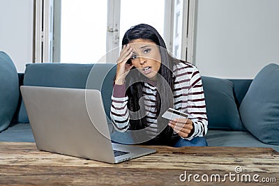 Young woman using laptop angry and stressed about her credit card bill Stock Photo