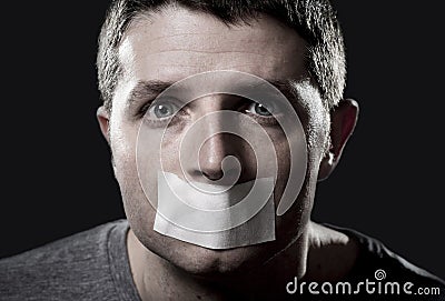 Attractive young man with mouth sealed on duct tape to prevent him from speaking Stock Photo