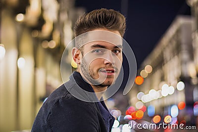 Attractive young man portrait at night with city lights Stock Photo