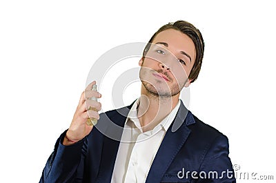 Attractive young man spraying perfume, using fragrance Stock Photo