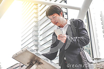 Attractive young man standing front big digital screen with basic tower map data with mobile. Stock Photo