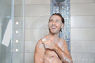 Attractive young man taking shower with soap Stock Photo