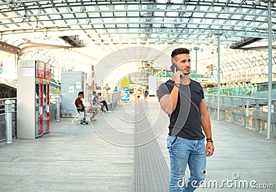 Attractive young man in train station using cellphone Stock Photo