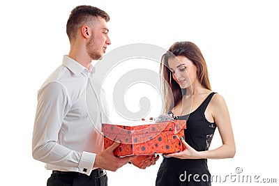 An attractive young man in a white shirt brought cute girl big red gift Stock Photo