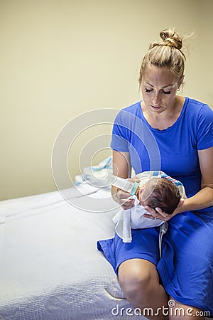 Young mother bottle feeding her newborn baby boy Stock Photo