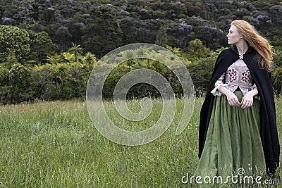 Red-haired 18th century woman wandering in the wilderness Stock Photo