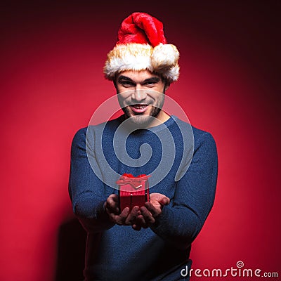 Attractive young santa giving you a small red gift Stock Photo