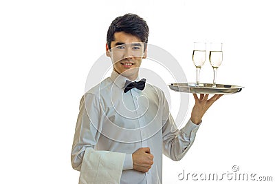 Attractive young waiter raised his hand tray with two glasses and smiling Stock Photo