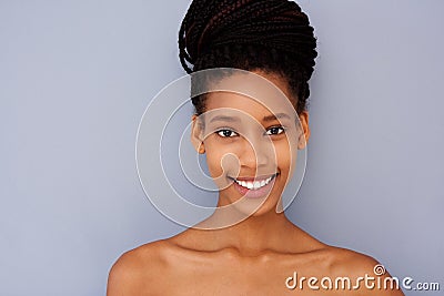 Attractive young woman against gray wall with naked shoulders Stock Photo