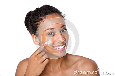 Attractive young woman applying cream on face Stock Photo