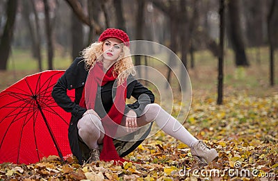 Attractive young woman in a autumn fashion shoot. Beautiful fashionable young girl with red accessories outdoor Stock Photo