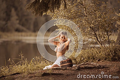 Attractive young woman with beautiful long blond hair sitting topless Stock Photo