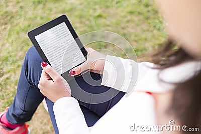 Attractive young woman with e-book/tablet in the park Stock Photo