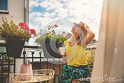 Attractive young woman enjoying vacations and drinking coffee on hotel balcony Stock Photo