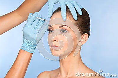 Attractive young woman gets cosmetic injection of botox. Stock Photo