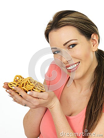 Attractive Young Woman Holding A Handful Of Salted Pretzels Stock Photo
