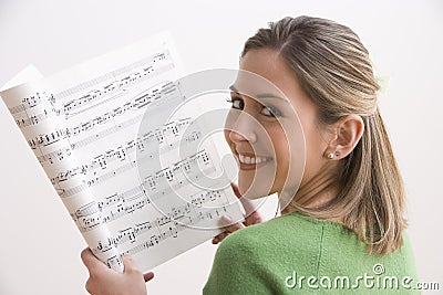 Attractive Young Woman Holding Sheet Music Stock Photo