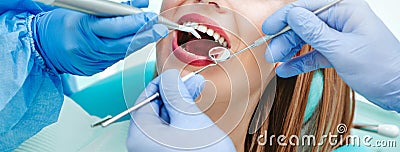 Attractive young woman with natural white teeth in dental clinic. Hands doctor dentist with medical tools. Healthy teeth concept Stock Photo