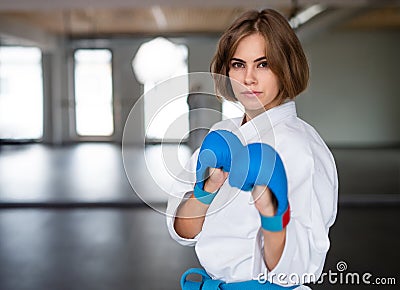 A young woman practising karate indoors in gym. Stock Photo