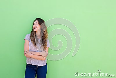 Attractive young woman smiling and looking away on green background Stock Photo