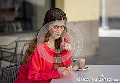 Attractive young woman using smart mobile phone dating app in a coffee shop outside terrace Stock Photo