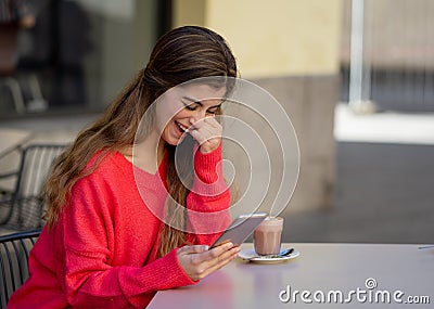 Attractive young woman using smart mobile phone dating app in a coffee shop outside terrace Stock Photo