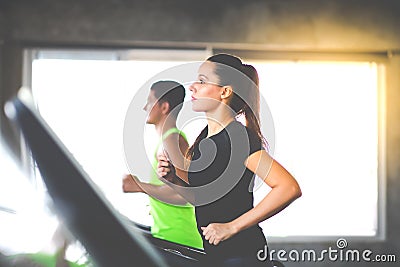 Attractive young woman and female running on treadmill machine at gym sports club. Fitness Healthy lifestye and workout at gym Stock Photo