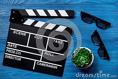 Attributes of film director. Movie clapperboard and sunglasses on blue wooden table background top view Stock Photo