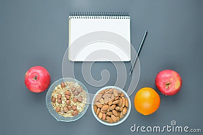 Count calories of healthy food snecks: oatmeal, almonds, apple, orange. Stock Photo