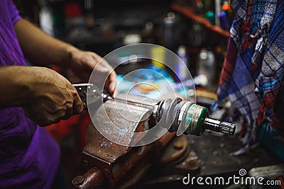 ATV constant-velocity CV joint repair by hands in old garage Stock Photo