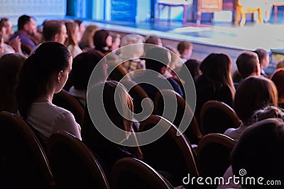The audience in the theater watching a play. The audience in the hall: adults and children Editorial Stock Photo