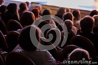 The audience in the theater watching a play. The audience in the hall: adults and children Editorial Stock Photo