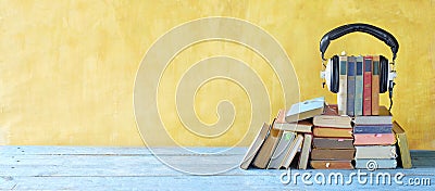 Audio book concept with large heap of books and vintage headphones, good copy space Stock Photo