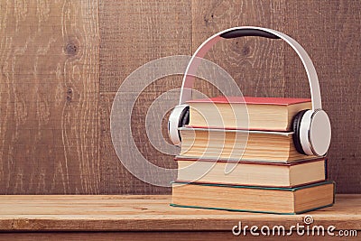 Audio books concept with stack of old book and headphones on wooden table Stock Photo