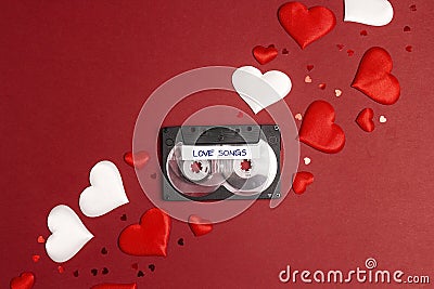 Audio cassette tape with love songs and hearts on red background. Romantic mood music concept Stock Photo