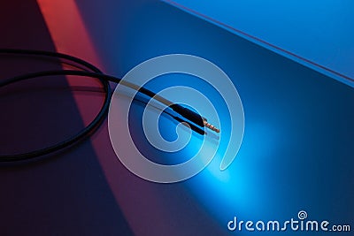 Audio Headphones and Microphones Cable Jack connector, Dark Background and colorful Light. Stock Photo