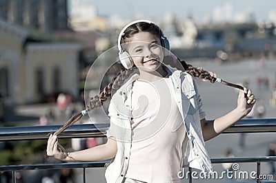 Audio tour headphones gadget. City guide and audio tour. Girl little tourist kid explore city using audio guide Stock Photo