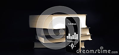 Audiobooks concept. Smartphone screen with audiobook application on paper books black background. Concept of education Stock Photo