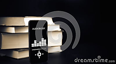 Audiobooks concept. Smartphone screen with audiobook application on paper books black background. Concept of education Stock Photo
