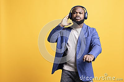 Audiophile enjoying songs on high fidelity headphones, studio background Stock Photo