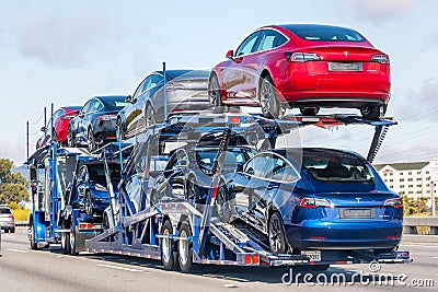 Aug 10, 2019 Burlingame / CA / USA - Car transporter carries Tesla Model 3 new vehicles on a freeway in San Francisco bay area, Editorial Stock Photo